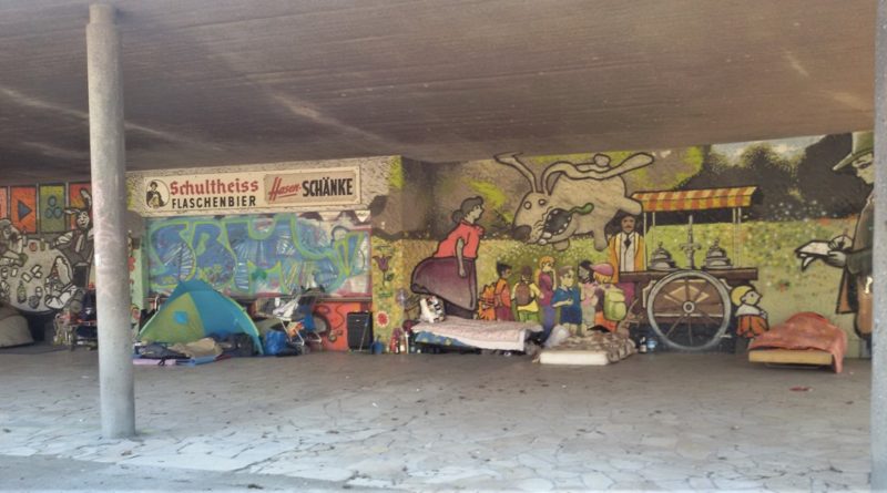 Rough sleepers in front of a mural